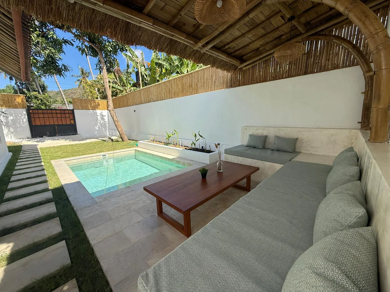 Built-in sofa under the thatched pergola, next to the pool